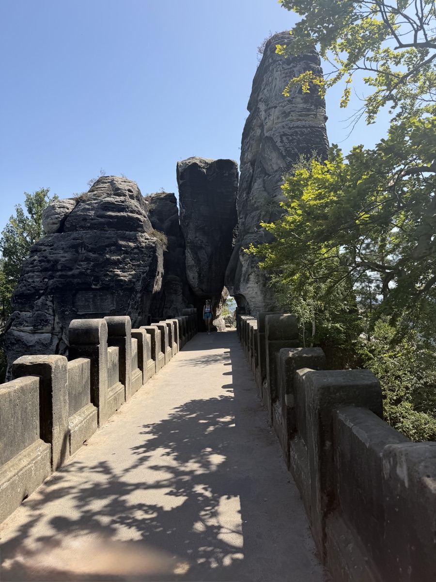 Steinbrücke zwischen hohen Felsnadeln, im Hintergrund blauer Himmel