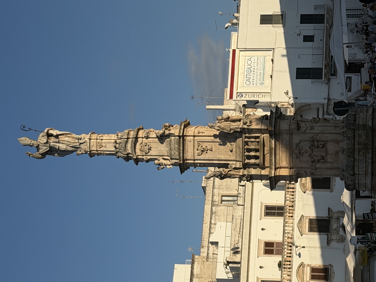 Die hohe Säule des heiligen Oronzo mit Heiligenstatue auf einem Platz in Ostuni